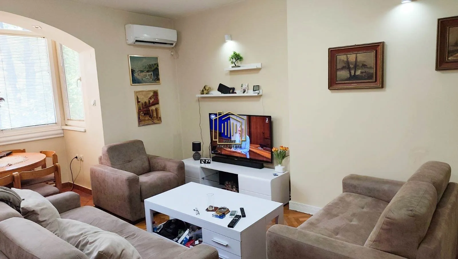 Living room with a seating set, white coffee table, and a TV.