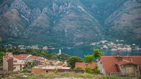 Pogled na zaliv i planine sa krovovima kuća u prvom planu. - image 11