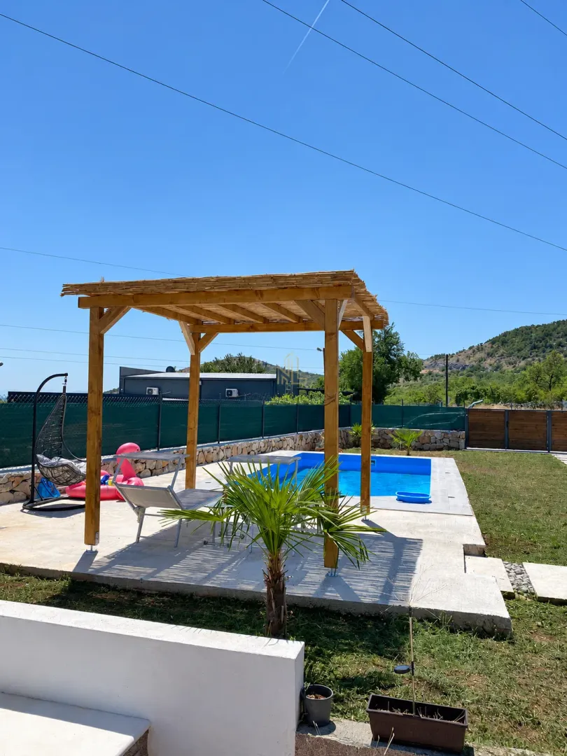 Yard with a swimming pool, wooden gazebo, and sun loungers.