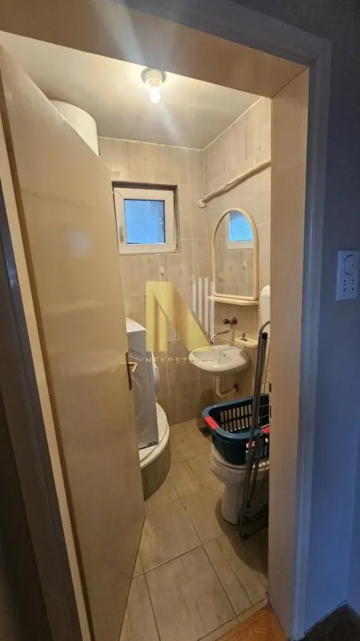 Manje kupatilo sa sanitarijama i veš mašinom.