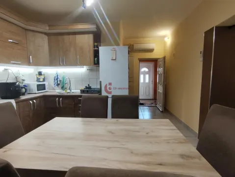 Kuhinja sa drvenim elementima i trpezarijskim stolom. - image 10