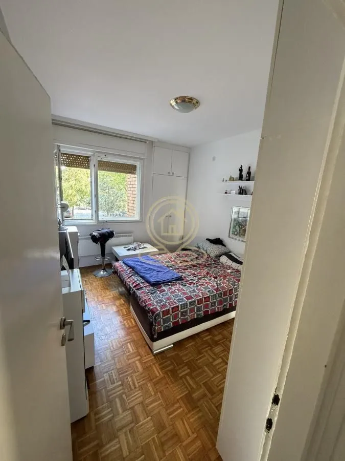 View of the bedroom with a bed, wardrobe, and window.