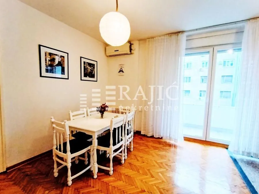 Dining area with a white table and chairs in the living room.