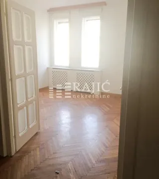 Empty room with hardwood floors and windows. - image 11