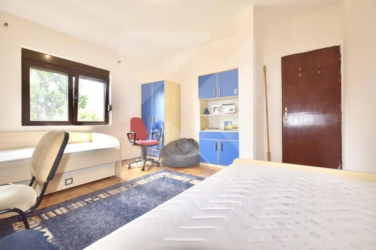 Furnished bedroom with a bed, desk, and wardrobes.