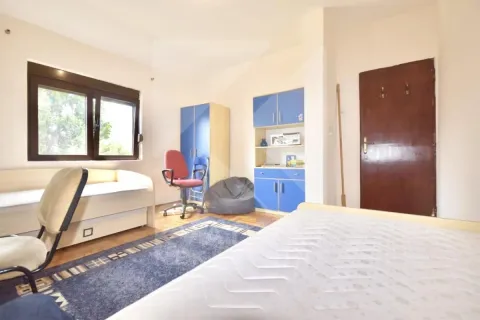 Furnished bedroom with a bed, desk, and wardrobes. - image 10