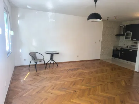 Prazna dnevna soba sa parketom i pogledom na kuhinju. - image 3