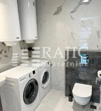 Bathroom equipped with sanitary ware, washing machine, and water heaters. - image 2