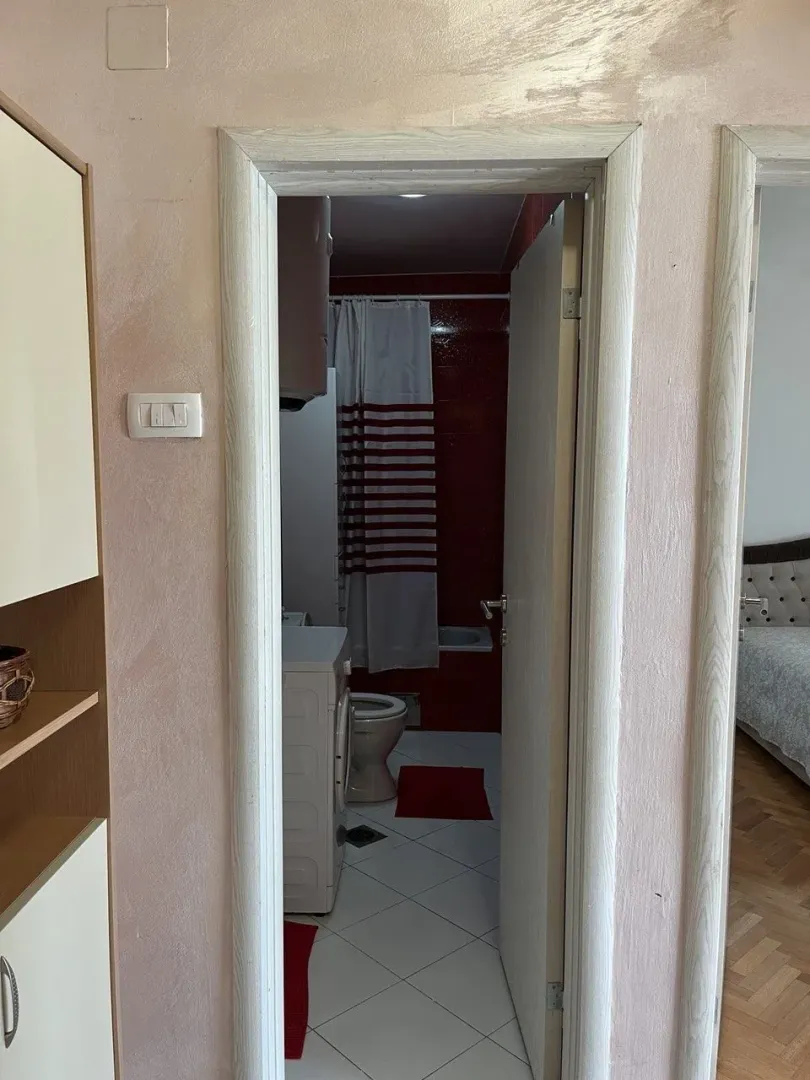 View through the doorway into a bathroom with a washing machine.