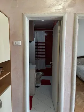 View through the doorway into a bathroom with a washing machine. - image 5