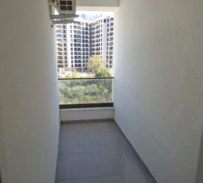 Empty balcony with a view of neighboring buildings and greenery. - image 13