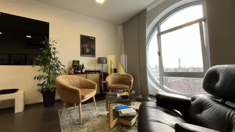 Living room furnished with armchairs, a sofa, and a large round window. - image 42