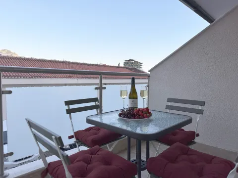 Furnished terrace with a table, chairs, and a view of the surroundings. - image 6
