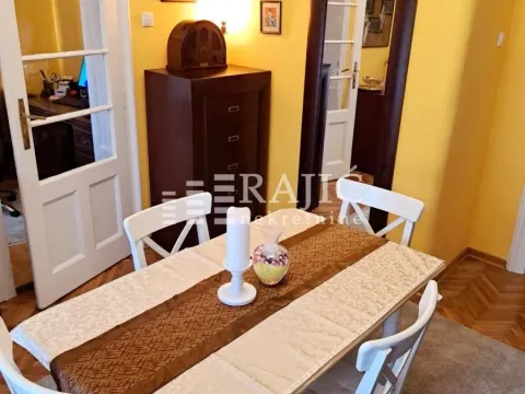 Dining area with a table and white chairs in an apartment. - image 18