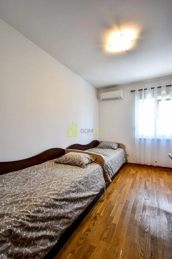 Bedroom with two single beds and hardwood flooring.