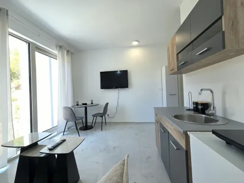 Modern kitchen with a dining table and living area corner. - image 2