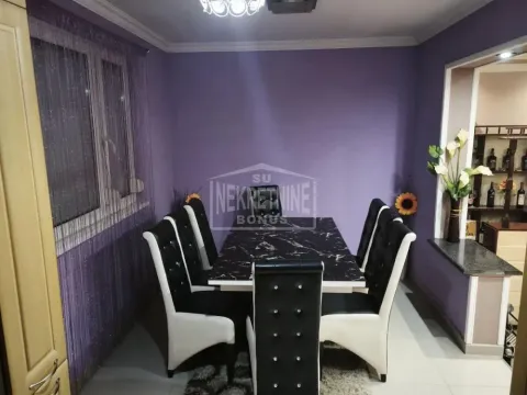 Trpezarija sa crnim stolom i stolicama u ljubičastoj prostoriji. - image 7