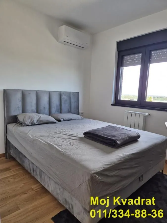 Bedroom with a double bed, air conditioning unit, and a window.