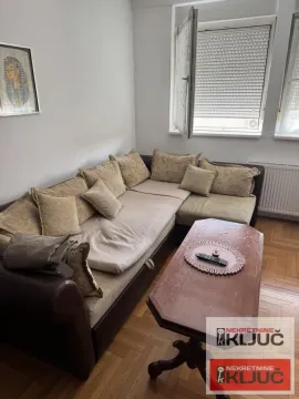 Dnevna soba sa ugaonom garniturom i drvenim stočićem. - image 2