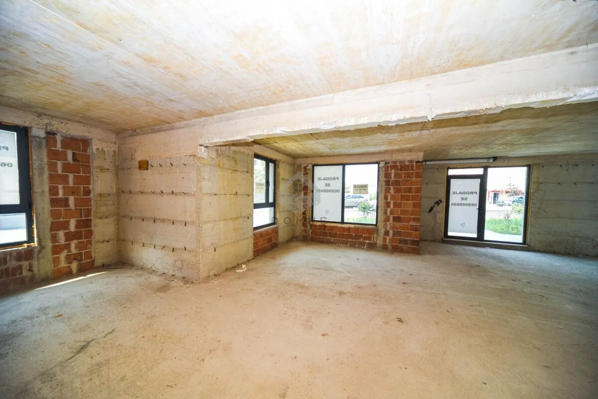 Unfinished commercial space in grey phase with concrete floors and walls.