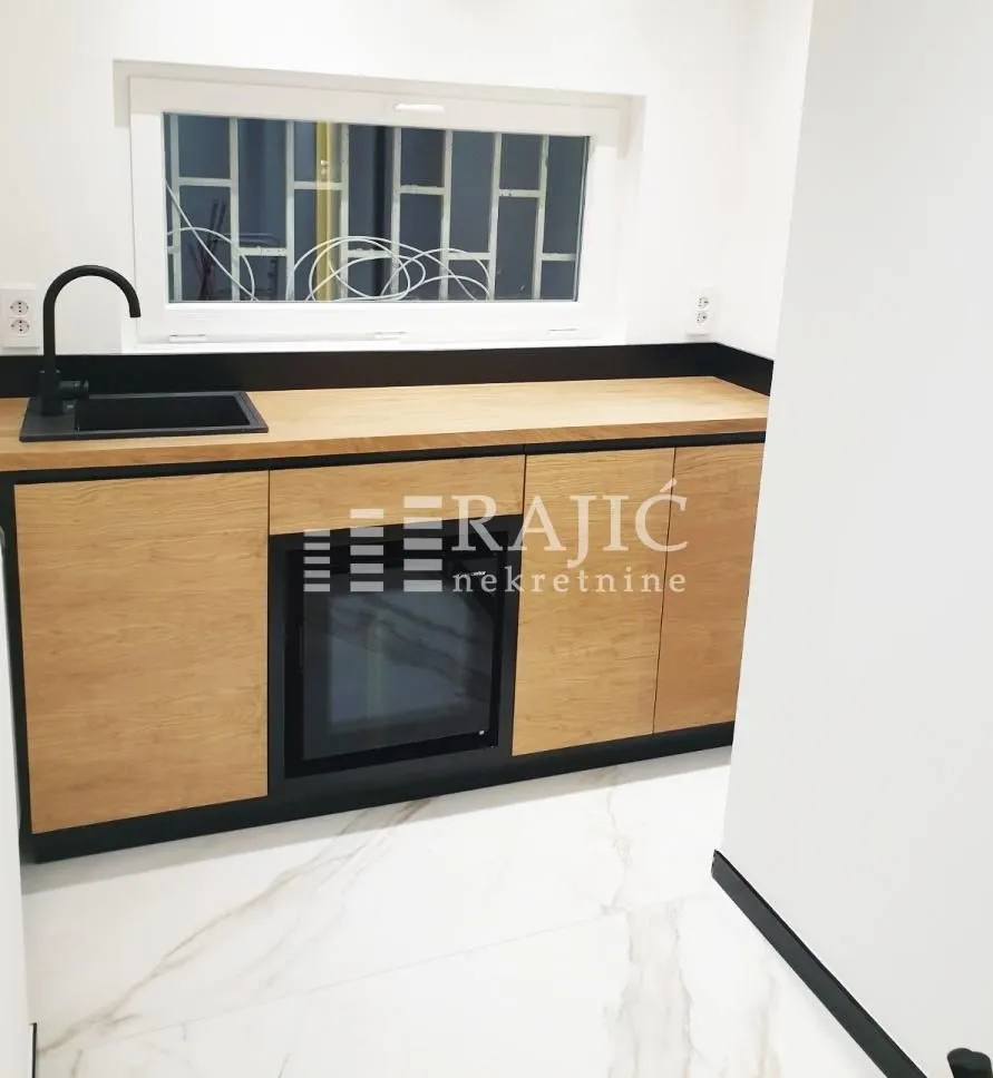 Modern kitchen with wooden elements and a built-in oven.