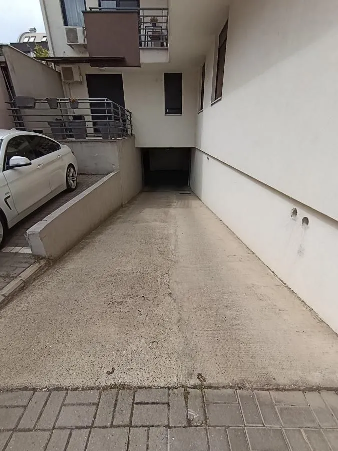 Entrance ramp to the underground garage of the building with a parking space.