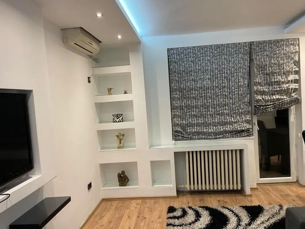 Living room with built-in shelves and an air conditioner.