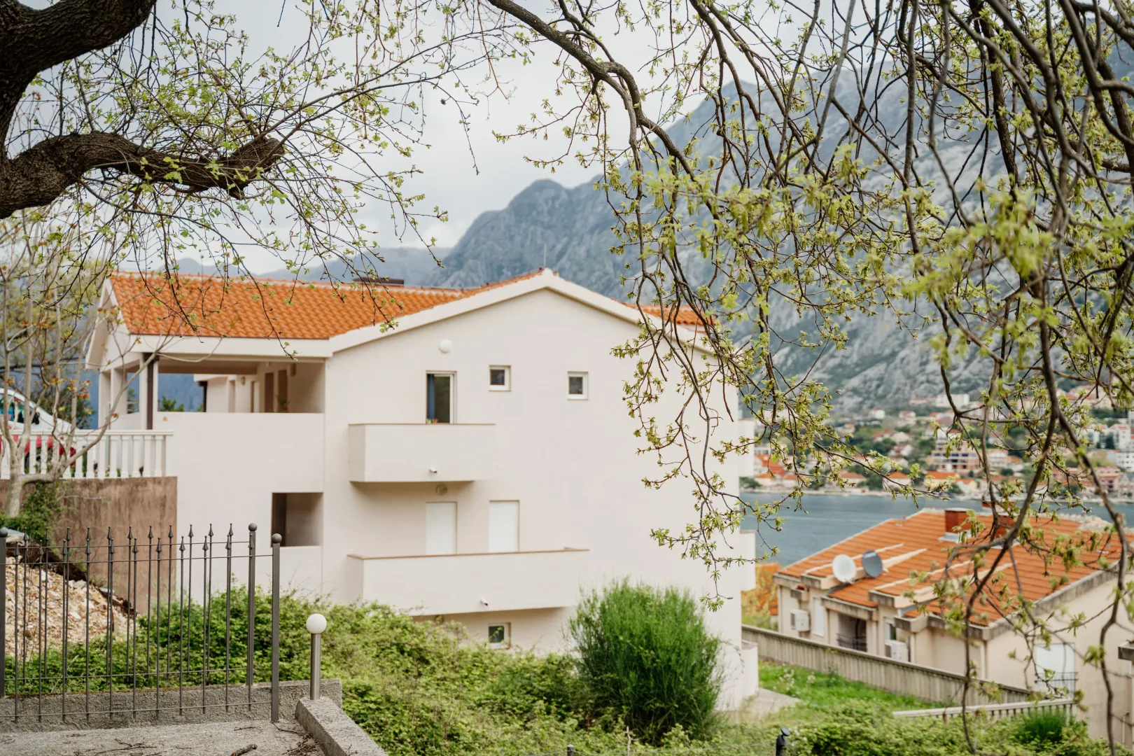Pogled na spoljašnjost kuće sa balkonom i okruženjem.