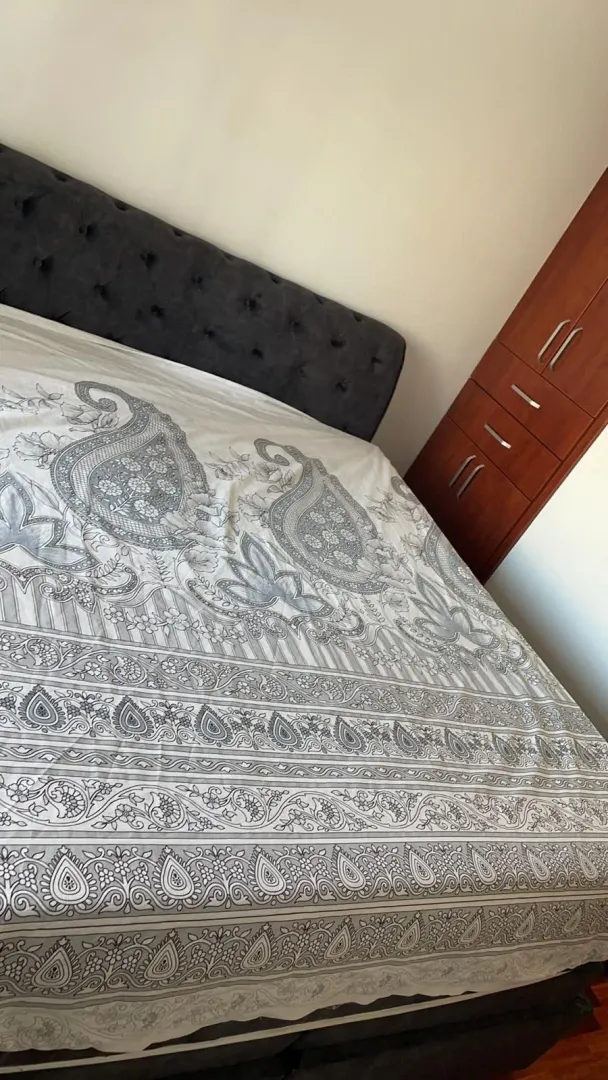 Spavaća soba sa velikim krevetom i drvenim ormarom.