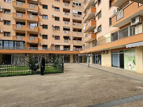 Courtyard and facade of a residential building with commercial spaces on the ground floor.