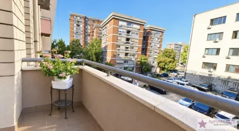 Small tiled balcony with a railing and a view of surrounding buildings and parking. - image 14