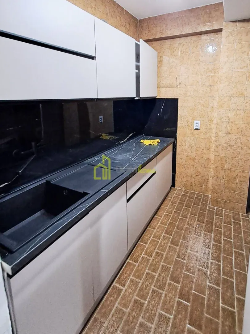 Small kitchen with white cabinets and dark countertop.