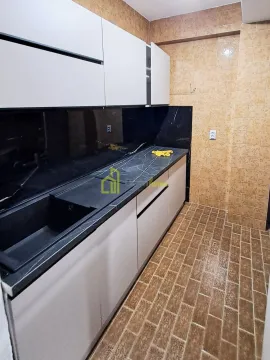 Small kitchen with white cabinets and dark countertop. - image 6