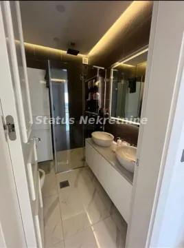 Modern bathroom with two sinks, a walk-in shower, and ambient lighting. - image 3