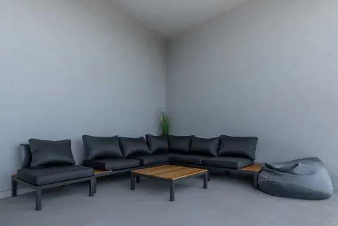 Terrace with dark built-in sofa set and a wooden coffee table. - image 14