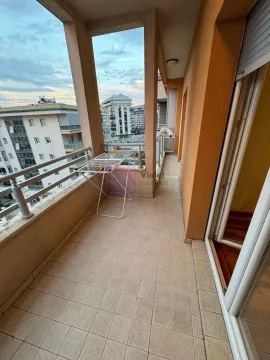 Spacious covered balcony with a view of the neighborhood and a clothes drying rack. - image 4