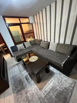 Living room with a corner sofa and a coffee table. - image 6