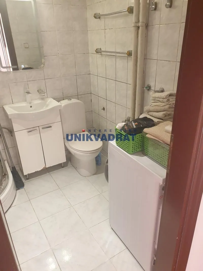 Manje kupatilo sa umivaonikom, WC šoljom i veš mašinom.