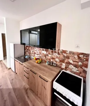 Modern kitchen with wooden lower cabinets and black upper cabinets. - image 3