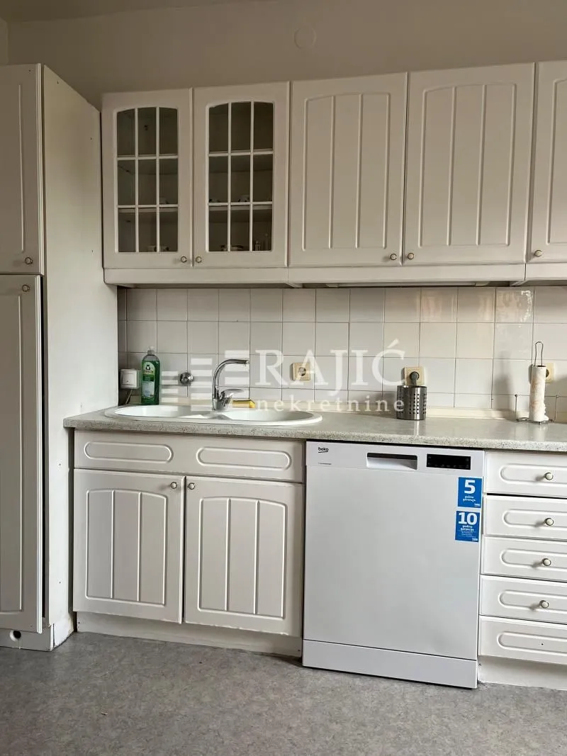 White kitchen with a sink and built-in units.