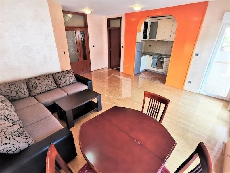 Living room with sofa set and dining table, overlooking the kitchen.