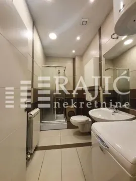 View of a modernly equipped bathroom with a shower cabin and a washing machine. - image 7