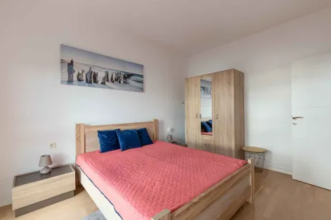 Bedroom with a double bed, wooden wardrobe, and bedside tables. - image 8