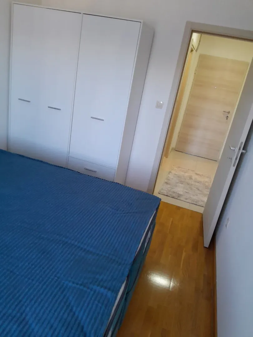 Furnished bedroom with a bed and wardrobe.