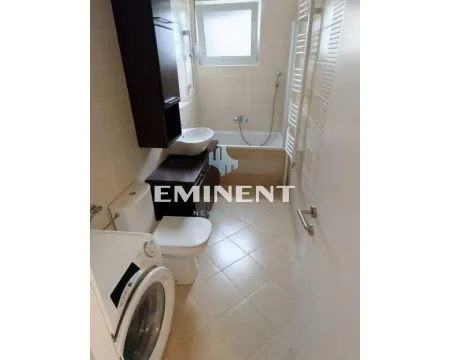 Small bathroom equipped with sanitary facilities, bathtub, and washing machine. - image 16