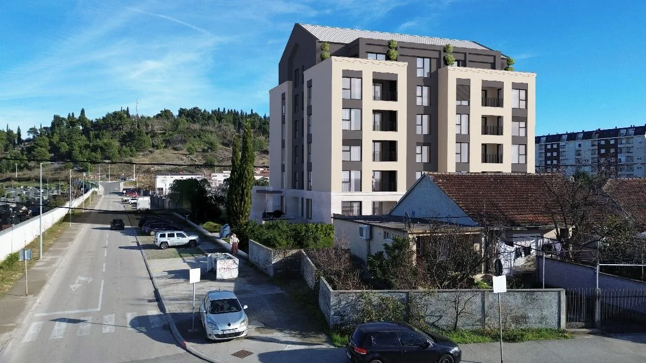 Spoljašnji izgled stambene zgrade sa okolinom i ulicom.
