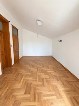 Empty room with wooden parquet flooring and white walls. - image 4