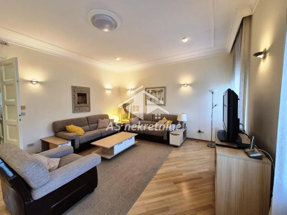 Living room with sofa set, coffee table, and television.
