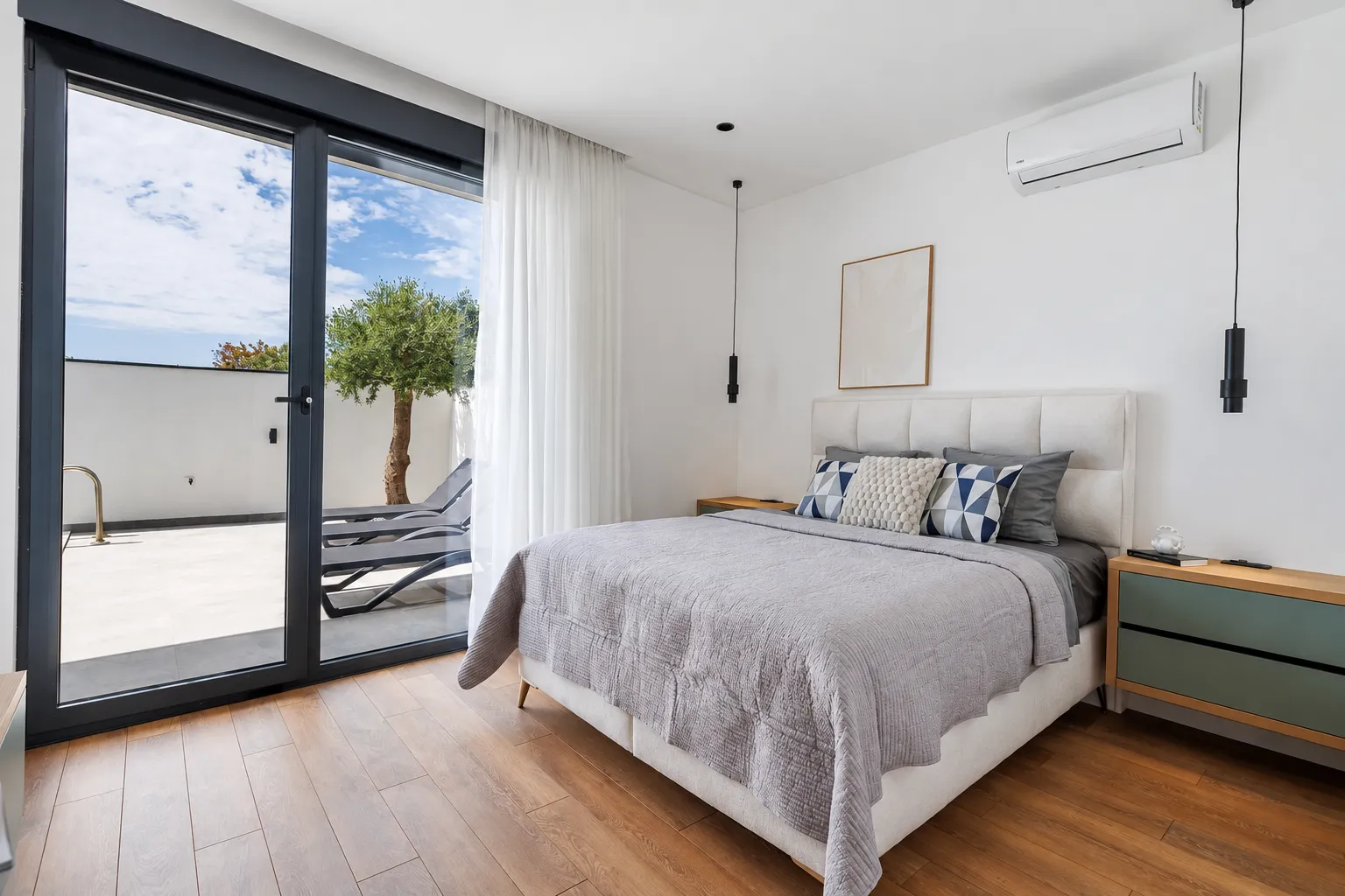 Modern bedroom with a double bed and access to the terrace.