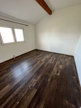 Prazna soba sa tamnim laminatom i bijelim zidovima. - image 13